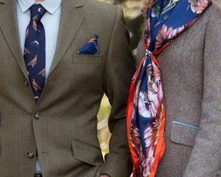 Clare Haggas couple wear silk tie, pocket square, and scarf. Styled in country wear for ladies and and men. Collection from Grouse Misconduct in Navy Blue