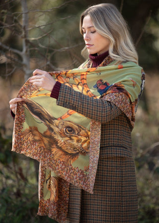 Woman holding a patterned scarf with animal designs outdoors
