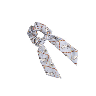 Luxury blue scrunchie with tails, showing a horse pattern, displayed on a white background