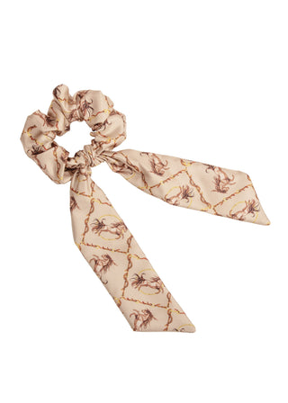 Beige scrunchie with a bow, showing a horse pattern, displayed on a white background